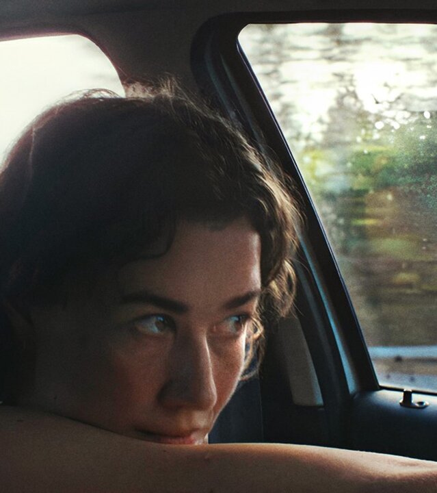 "Ivo": Palliativpflegerin Ivo (Minna Wündrich) sitzt am Steuer ihres Wagens. Sie blickt verträumt auf die Straße.