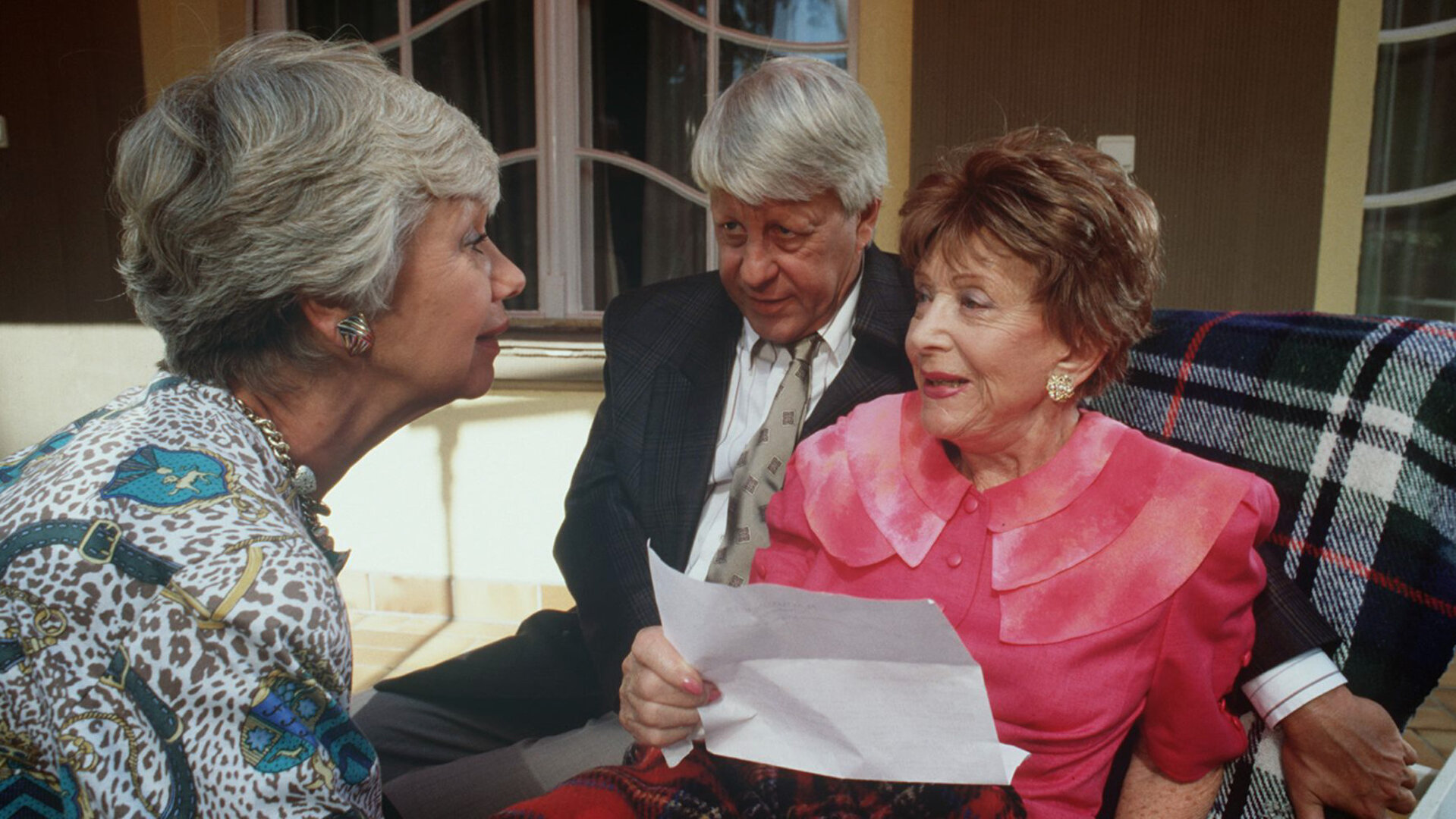 "Die Wicherts von nebenan: Antiquitäten": Hannelore (Maria Sebald) und Eberhard (Stephan Orlac) sitzen mit Oma Käthe (Edith Schollwer) auf der Terrasse und überreichen ihr ein Dankschreiben des Bischofs.