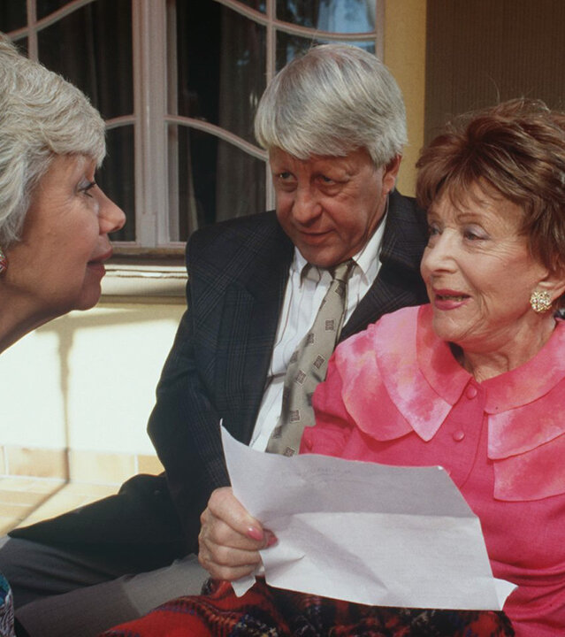 "Die Wicherts von nebenan: Antiquitäten": Hannelore (Maria Sebald) und Eberhard (Stephan Orlac) sitzen mit Oma Käthe (Edith Schollwer) auf der Terrasse und überreichen ihr ein Dankschreiben des Bischofs.