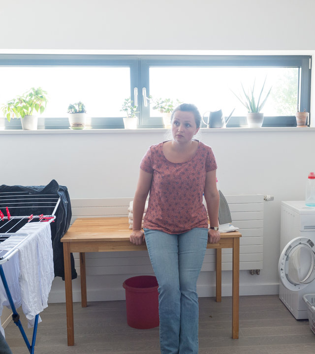 „SOKO Wismar – Klub der Aufreißer“: Lars Pöhlmann (Dominic Boeer) steht neben einem Wäscheständer und guckt zur Putzfrau Paula Sanders (Monika Oschek). Ein KTU-ler kniet neben der Waschmaschine und untersucht die Wäsche.