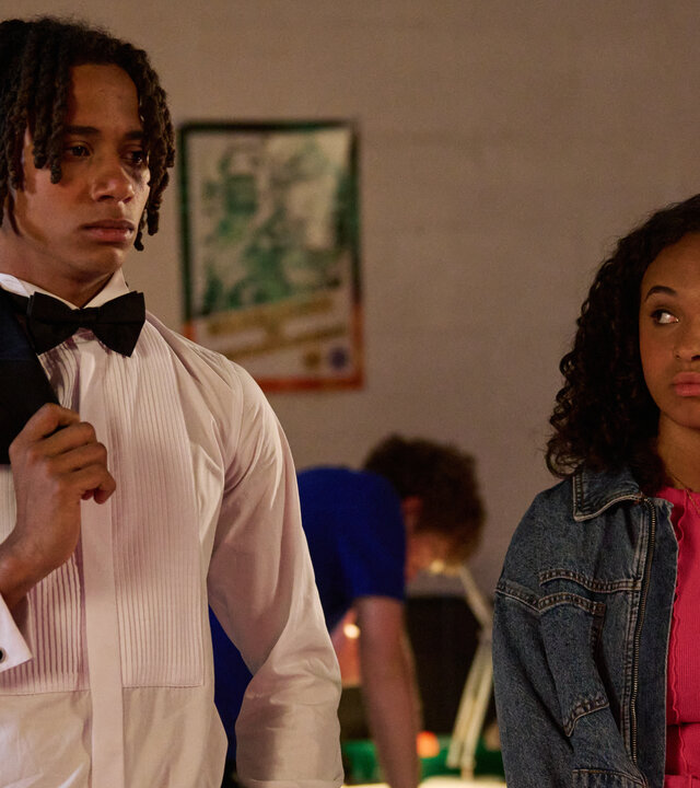 "Boarders - Welcome to St. Gilbert's - Rumors & Robots": Toby (Sekou Diaby) und Abby (Assa Kanouté) stehen nebeneinander in einem Raum. Er schaut nach vorne, sie blickt in seine Richtung.