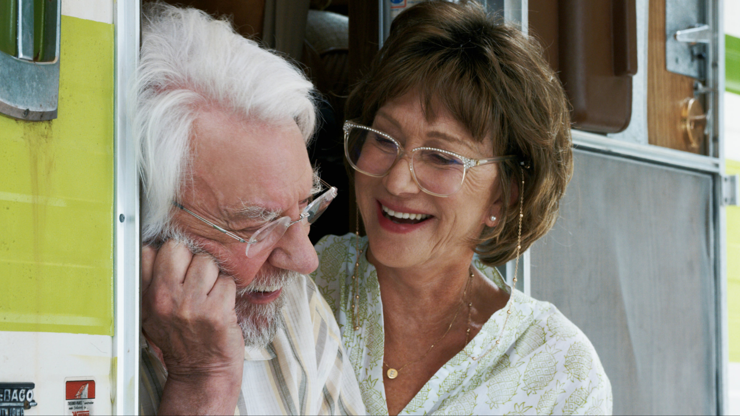"Das Leuchten der Erinnerung": Ella (Helen Mirren) und John Spencer (Donald Sutherland) sitzen lachend, bei geöffneter Tür, auf den Eingangsstufen ihres Wohnmobils.