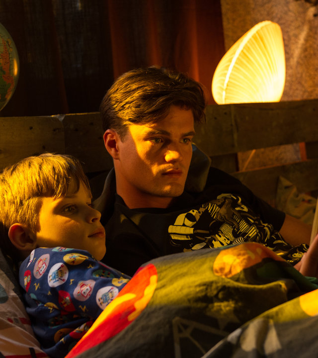 "SOKO Stuttgart - Crashman": Felix Kühn (Yannik Rebmann) liegt mit Toni Kühn (Paul Triller) im Bett und lässt sich von ihm einen Comic vorlesen.