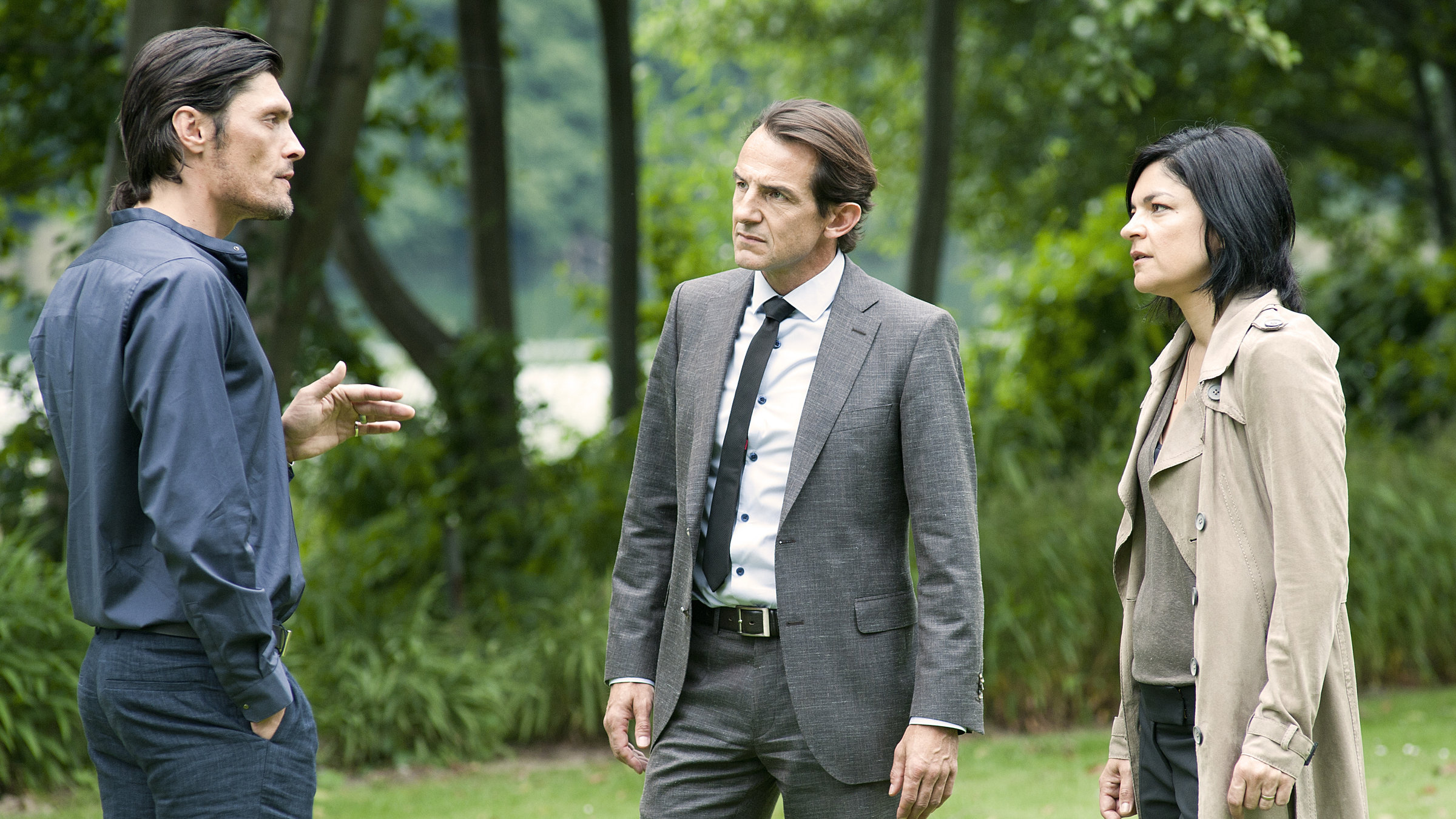 "Letzte Spur Berlin - Tauschgeschäft": Nikola Orsic (Stipe Erceg) steht Oliver Radek (Hans-Werner Meyer) und Mina Amiri (Jasmin Tabatabai) auf einem Rasen gegenüber und gestikuliert mit der Hand. Radek und Mina schauen ihn ernst an.