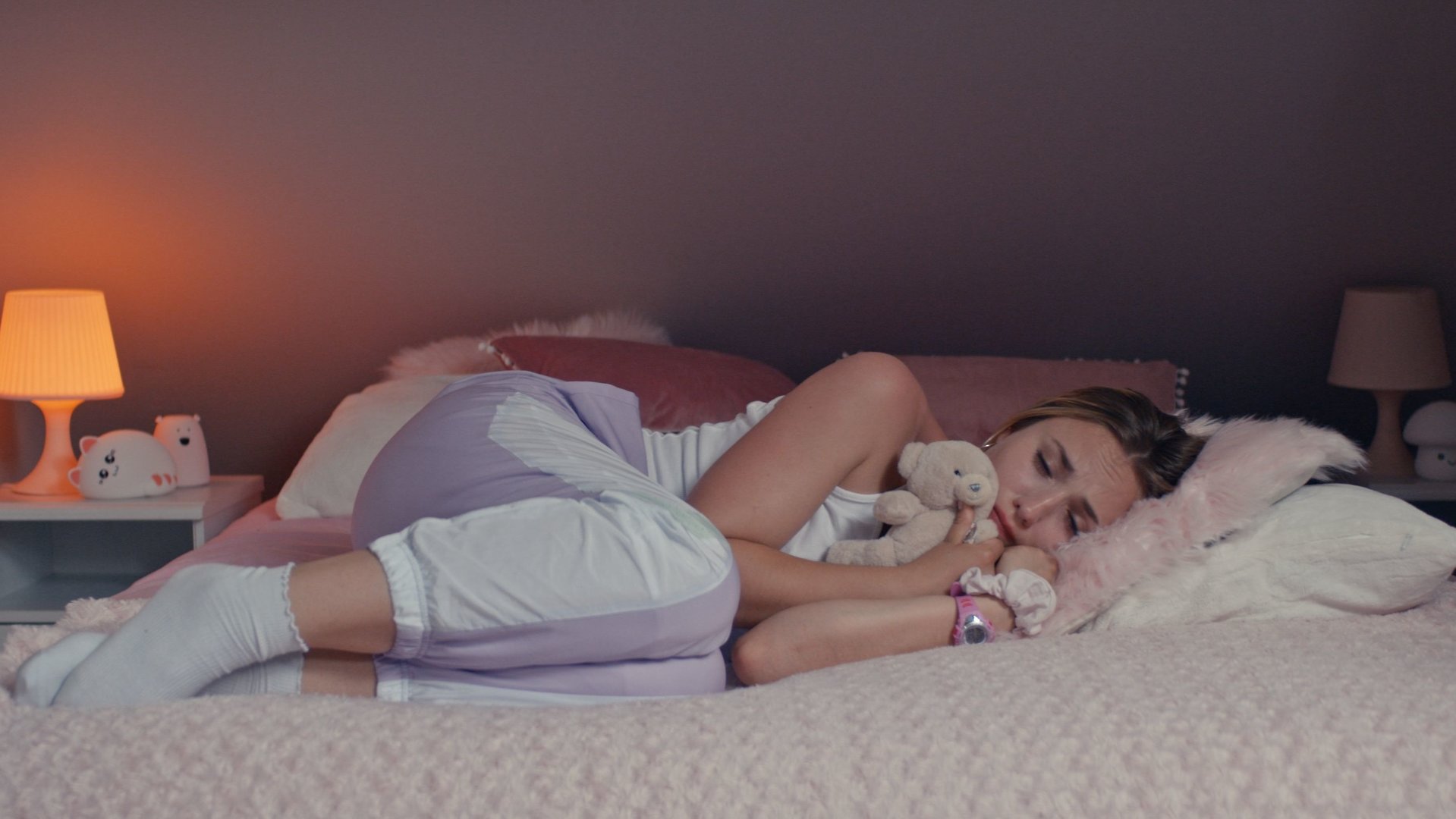 "Derby Girl - Pfau und Wolf": Lola Bouvier (Chloé Jouannet) liegt weinend in einem Bett. Sie hält einen Teddybären in ihrem Arm.