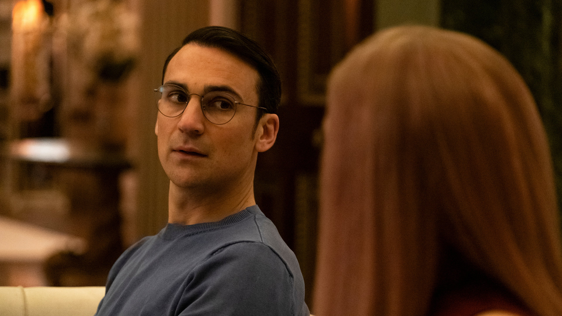 "Killing Eve – Das perfekte Paar": Aaron (Henry Lloyd-Hughes) sitzt neben Villanelle (Jodie Comer) auf einem Sofa und schaut sie aufrichtig an.
