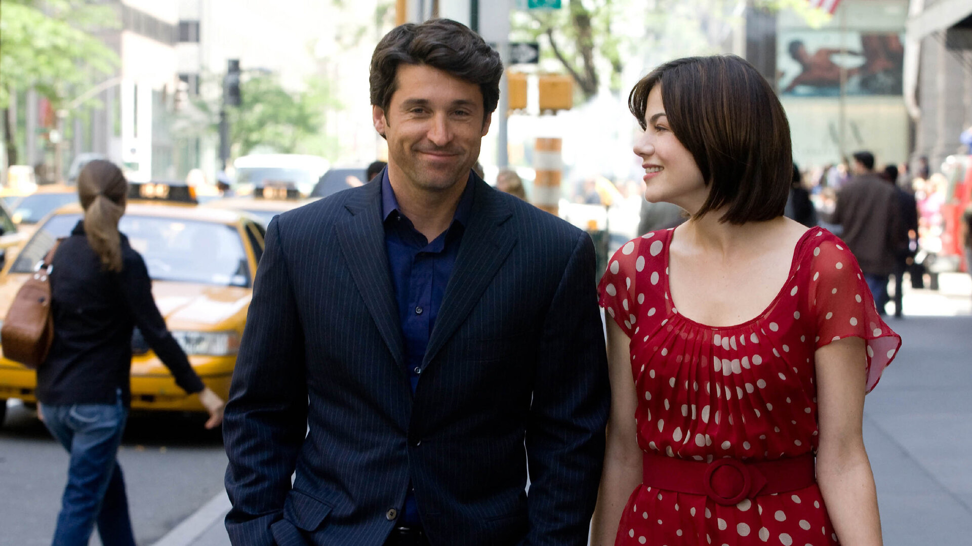 "Verliebt in die Braut": Hannah (Michelle Monaghan) und Tom (Patrick Dempsey) schlendern gemeinsam die Straße entlang. Während Tom lächelnd und gedankenverloren vor sich hinblickt, betrachtet Hannah ihn grinsend.