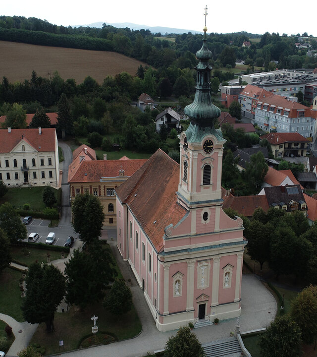 "Katholischer Gottesdienst - Der Herr ist mein Hirt, nichts wird mir fehlen": Luftbild: Die Stadtpfarrkirche des Heiligen Petrus und Paulus in Pinkafeld steht inmitten der sie umgebenden Häuser in einer kleinen Grünanlage.