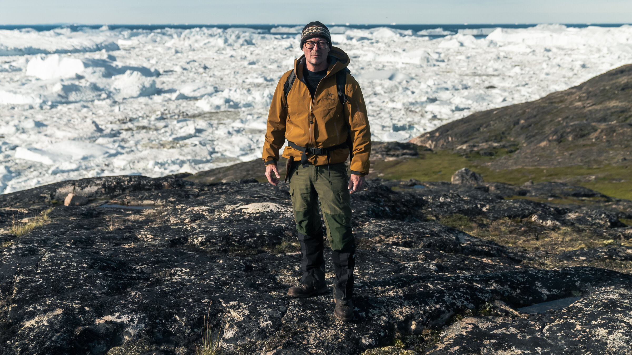 "Vor der Eiszeit - Jagd nach dem ältesten Erbgut der Welt": Eske Willerslev ist Evolutionsgenetiker und steht bei einer Expedition auf einer eisfreien Fläche, hinter ihm erstreckt sich eine schnee- und eisbedeckte Landschaft.