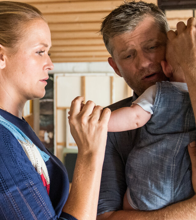 "Lena Lorenz - Schatten und Licht (2)": Markus Petri (Andreas Guenther) hält ein Baby auf dem Arm. Lena Lorenz (Judith Hoersch) steht daneben und hat tröstend den Arm des Babys gegriffen.