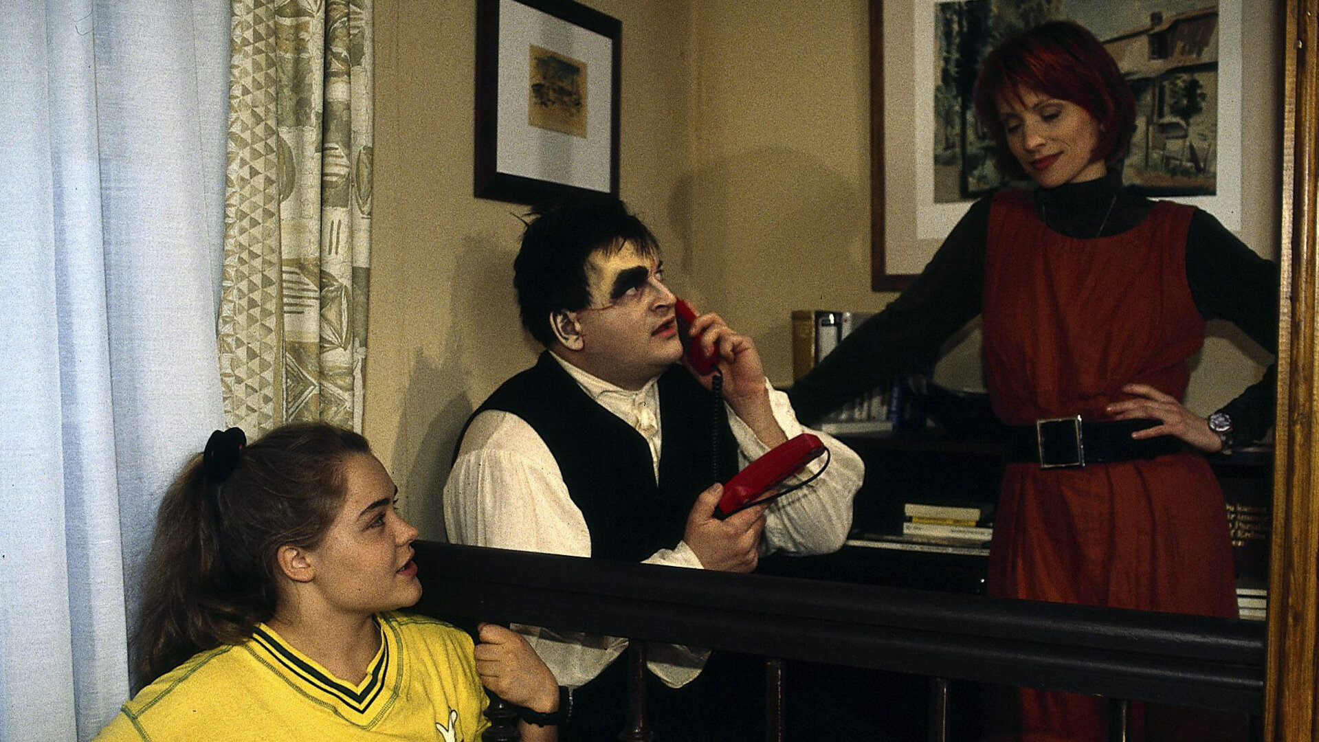 "Sprechstunde bei Dr. Frankenstein": Franzi (Fritzi Eichhorn), Charly (Silke Matthias), Lenni (Michael Trischan) befinden sich im Wohnzimmer, Lenni telefoniert.