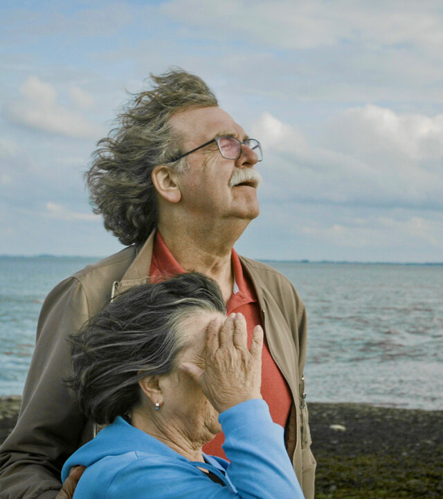 "Jenseits von Schuld": Ulla und Didi Högel stehen nebeneinander mit den Gesichtern dem Wind zugewandt am Strand.