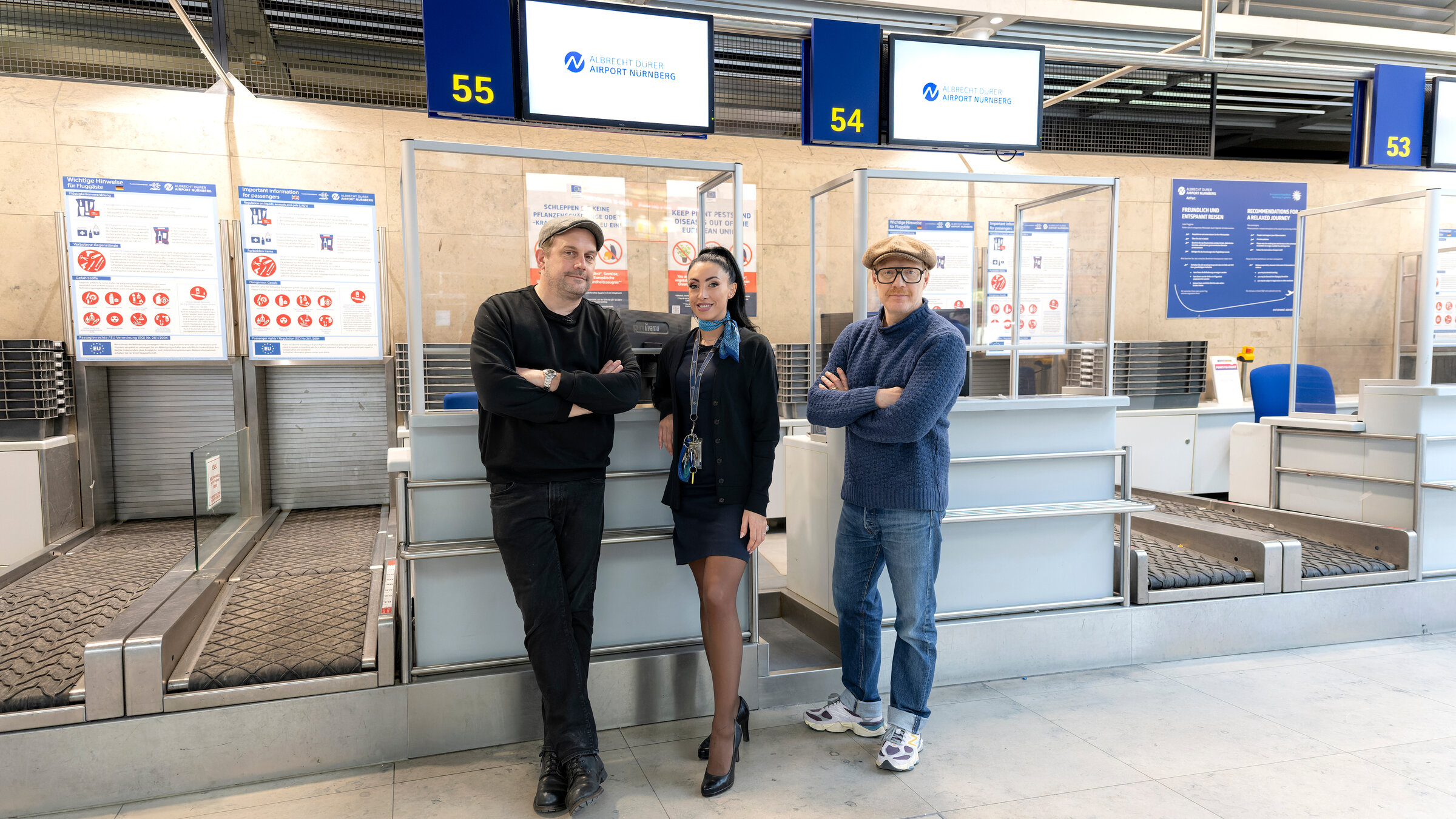 "Bezzel & Schwarz - Die Grenzgänger - Am Flughafen Nürnberg": Von links: Sebastian Bezzel, Mirella Baronetti (Check In und Boarding) und Simon Schwarz.