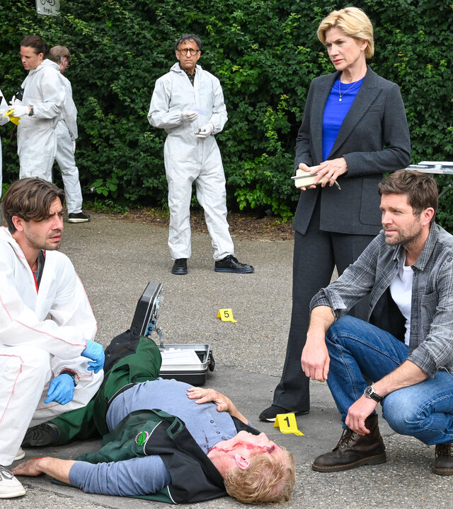 "SOKO Stuttgart - Hinter verschlossenen Türen": Die Leiche des Gärtners Christian Schwarz (Komparse) liegt auf einem Fußweg. An seinem Kopf klafft eine blutige Wunde. Rechts und links daneben knien Rechtsmediziner Dr. Benedikt Förster (Florian Wünsche) und Kriminalhauptkommissar Jo Stoll (Peter Ketnath). Dahinter steht die erste Kriminalhauptkommissarin Martina Seiffert (Astrid M. Fünderich). Alle drei schauen fragend in die Runde. Im Hintergrund steht der KTU-Leiter Jan Arnaud (Mike Zaka Sommerfeldt) und schaut zu ihnen, daneben arbeiten weitere Mitarbeiter der Spurensicherung und ein Beamter (Komparsen) ist vor Ort.