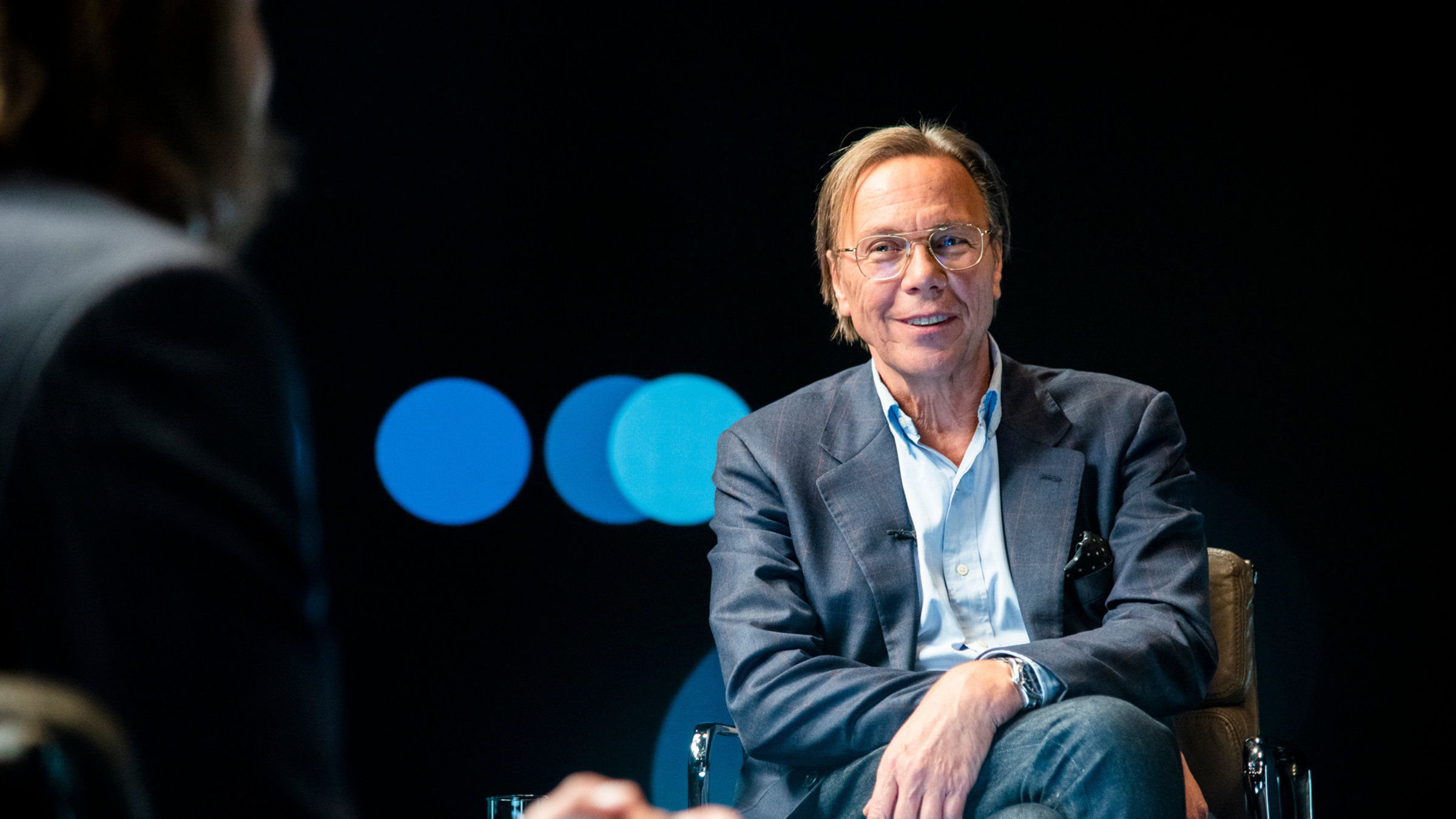 "Precht - Utopien - Rezepte für die Zukunft?": Harald Welzer sitzt Richard David Precht, der von hinten zu sehen ist, gegenüber und lächelt in die Kamera.