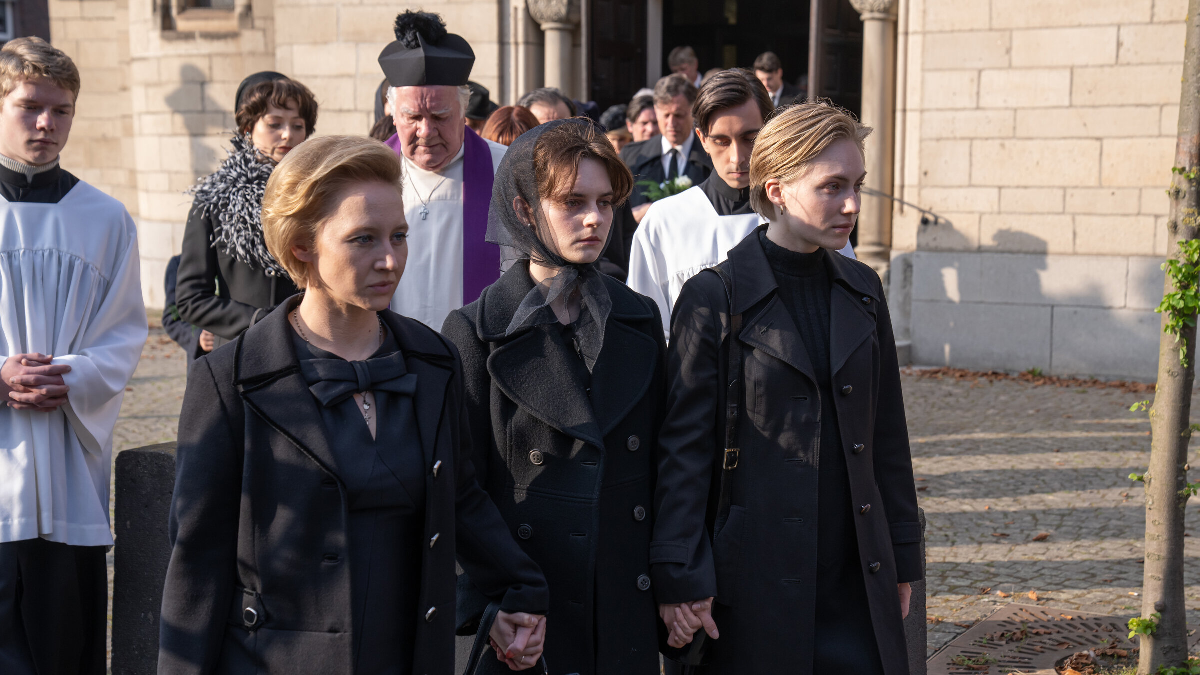 "Unsere wunderbaren Jahre: Blei": Winnes (Damian Hardung) Sarg wird aus der Kirche getragen. V.l.n.r.: Margot Anna Maria Mühe), Gundel (Vanessa Loibl) und Ulla (Elisa Schlott).