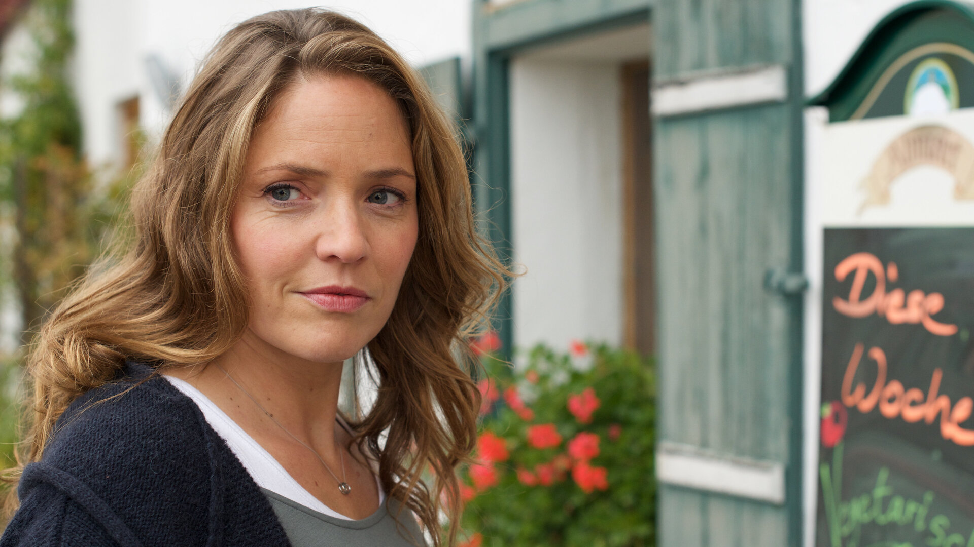 "Lena Lorenz - Ein Fall von Liebe": Lena Lorenz (Patricia Aulitzky) steht vor einem Gasthof; ihr Blick strahlt freudige Erwartung aus.