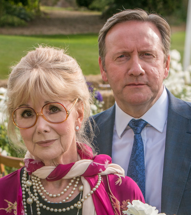 "Inspector Barnaby - Streicheln und töten": John Barnaby (Neil Dudgeon) und Delphi Hartley (Susan Hampshire) stehen auf einer Wiese mit blühenden Blumen und schauen in eine unbestimmte Richtung.