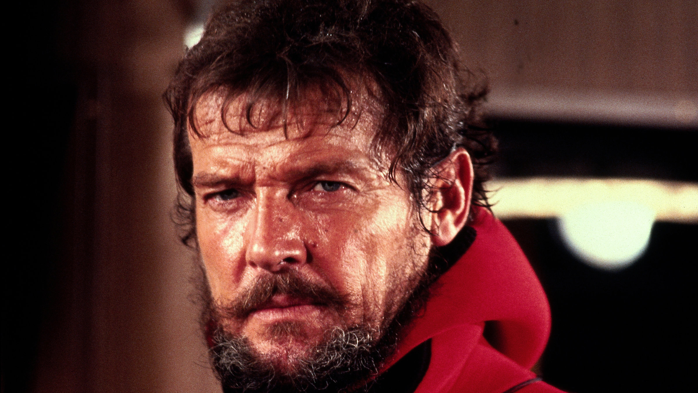 "Sprengkommando Atlantik": Nahaufnahme von Rufus Excalibur ffolkes (Roger Moore), mit Bart und grimmigem Blick. Er trägt einen Taucheranzug.