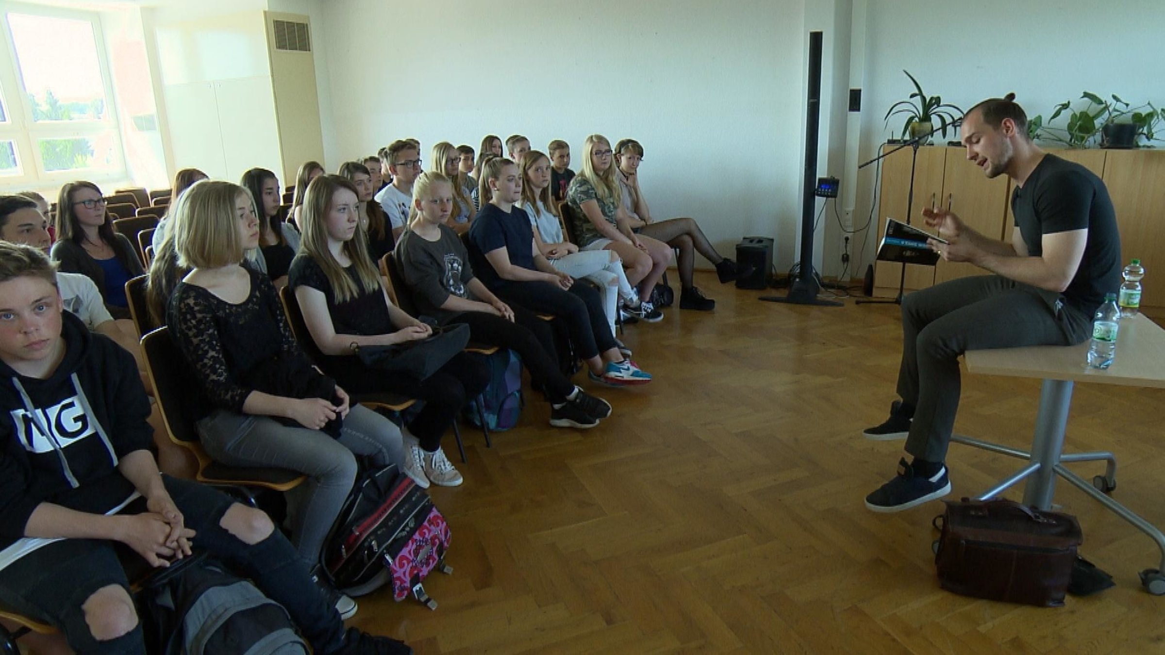 "Mein Land, Dein Land: Crystal Meth - Wie die Droge Schulhöfe verseucht": "GZSZ"-Schauspieler Eric Stehfest liest vor einer Gruppe Schüler.