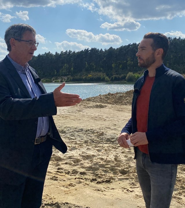 "XY gelöst": Ein Ermittler steht zusammen mit Sven Voss in der Nähe eines Gewässers. Der Beamte spricht mit Sven Voss.