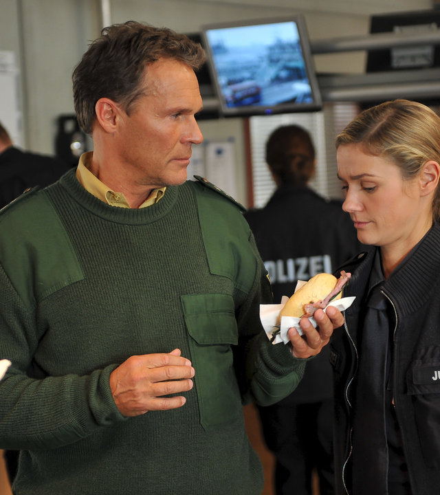 "Notruf Hafenkante - Bärendienst": Peter (Christian Tramitz) bietet Franzi (Rhea Harder) sein Hamburger Fischbrötchen an. Diese blickt ziemlich skeptisch.