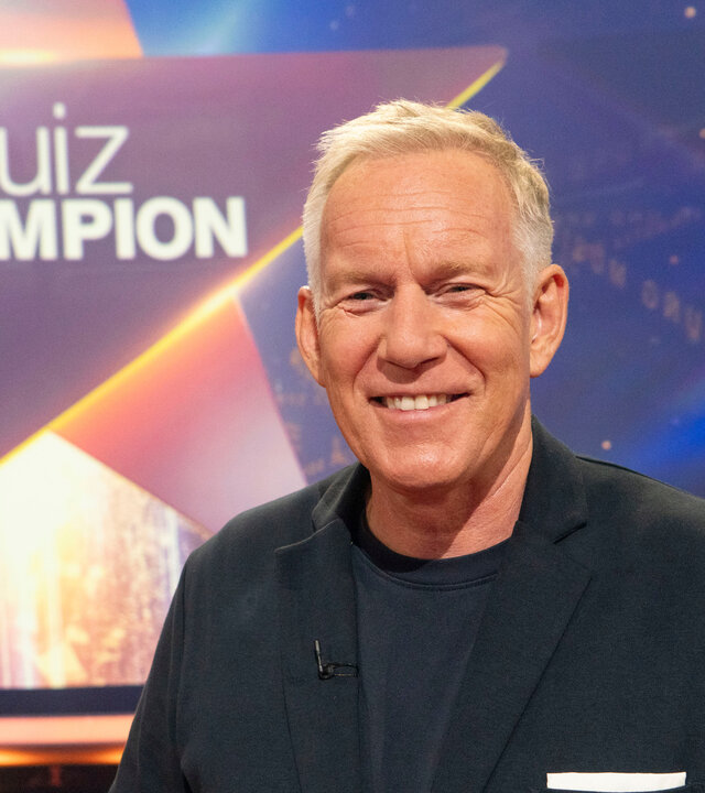 "Der Quiz-Champion - Das Spenden-Special": Johannes B. Kerner steht vor Logo im Studio und lacht in die Kamera.