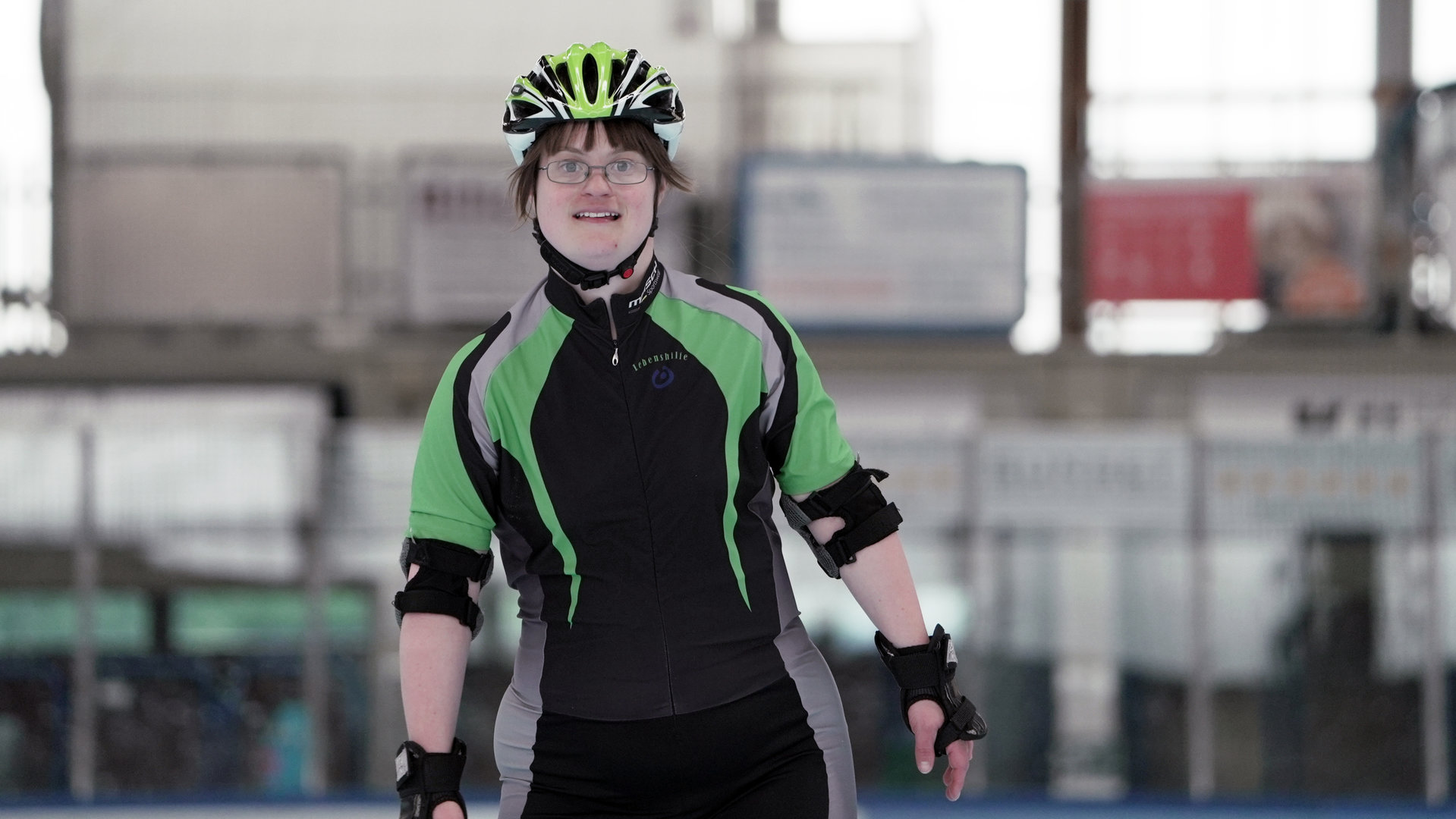 "einfach Mensch - Stefanie Wiegel: Auf acht Rollen zu den Special Olympics '23": Stefanie Wiegel steht auf der Laufbahn im Trainingsanzug.