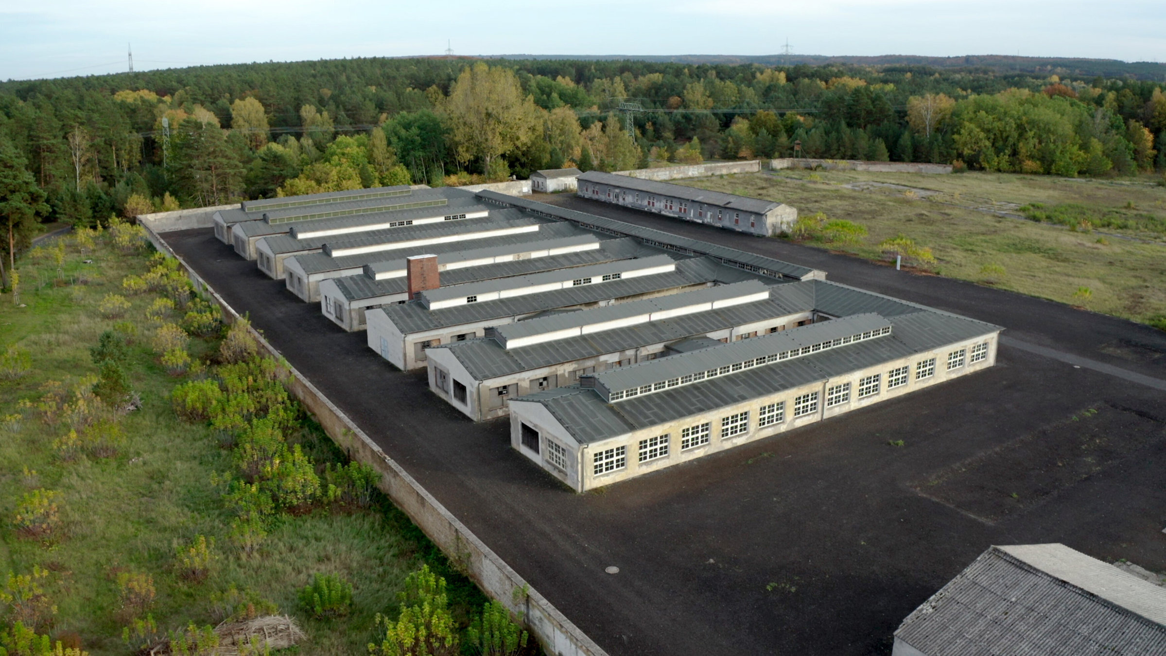 "Blutiger Boden, reiche Gewinne – Die Wirtschaftsmacht der SS": Produktionshallen der ehem. SS-eigenen "Gesellschaft für Textil und Lederverwertung mbH" im KZ Ravensbrück.