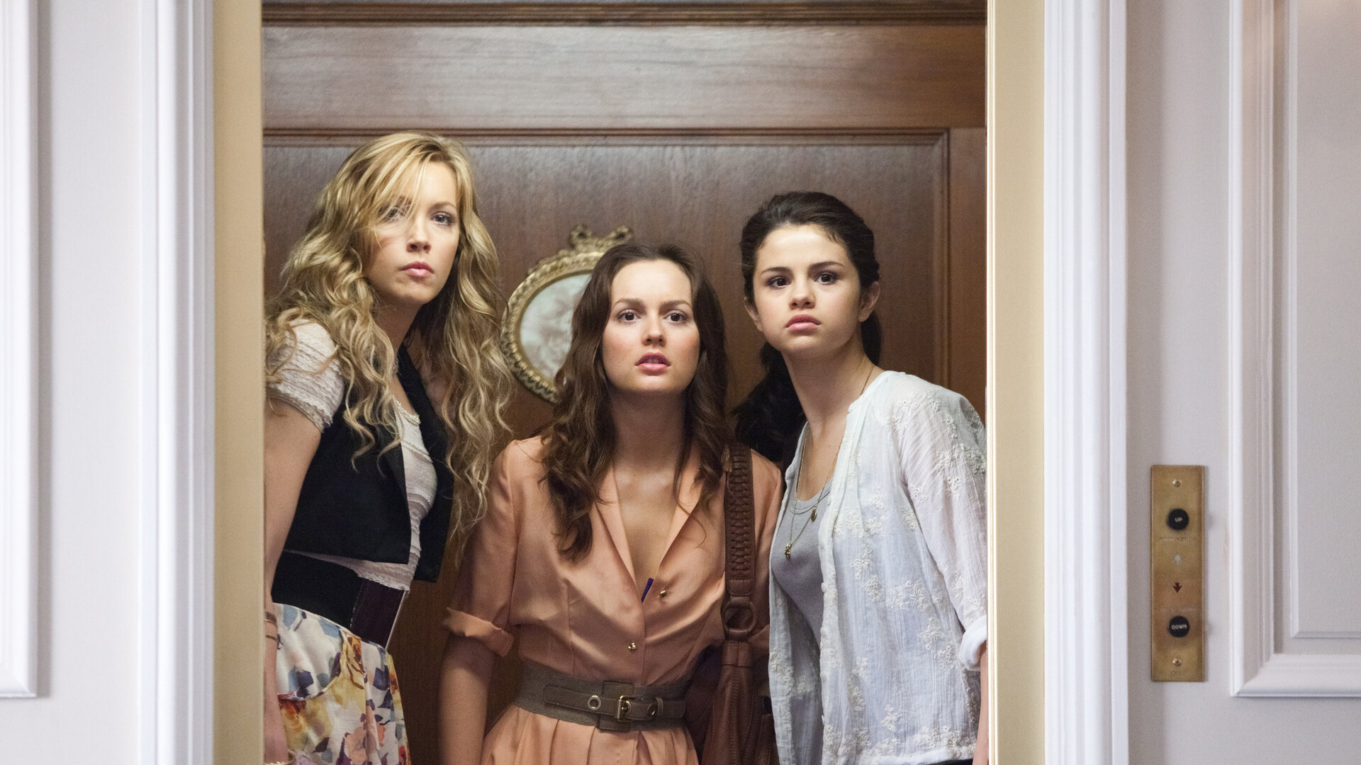 "Plötzlich Star": Grace (Selena Gomez), Emma (Katie Cassidy) und Meg (Leighton Meester) stehen in einem Fahrstuhl. Ihre Gesichter sind von Erstaunen geprägt, während die offenen Türen des Fahrstuhls den Blick auf den Raum vor ihnen freilegen.
