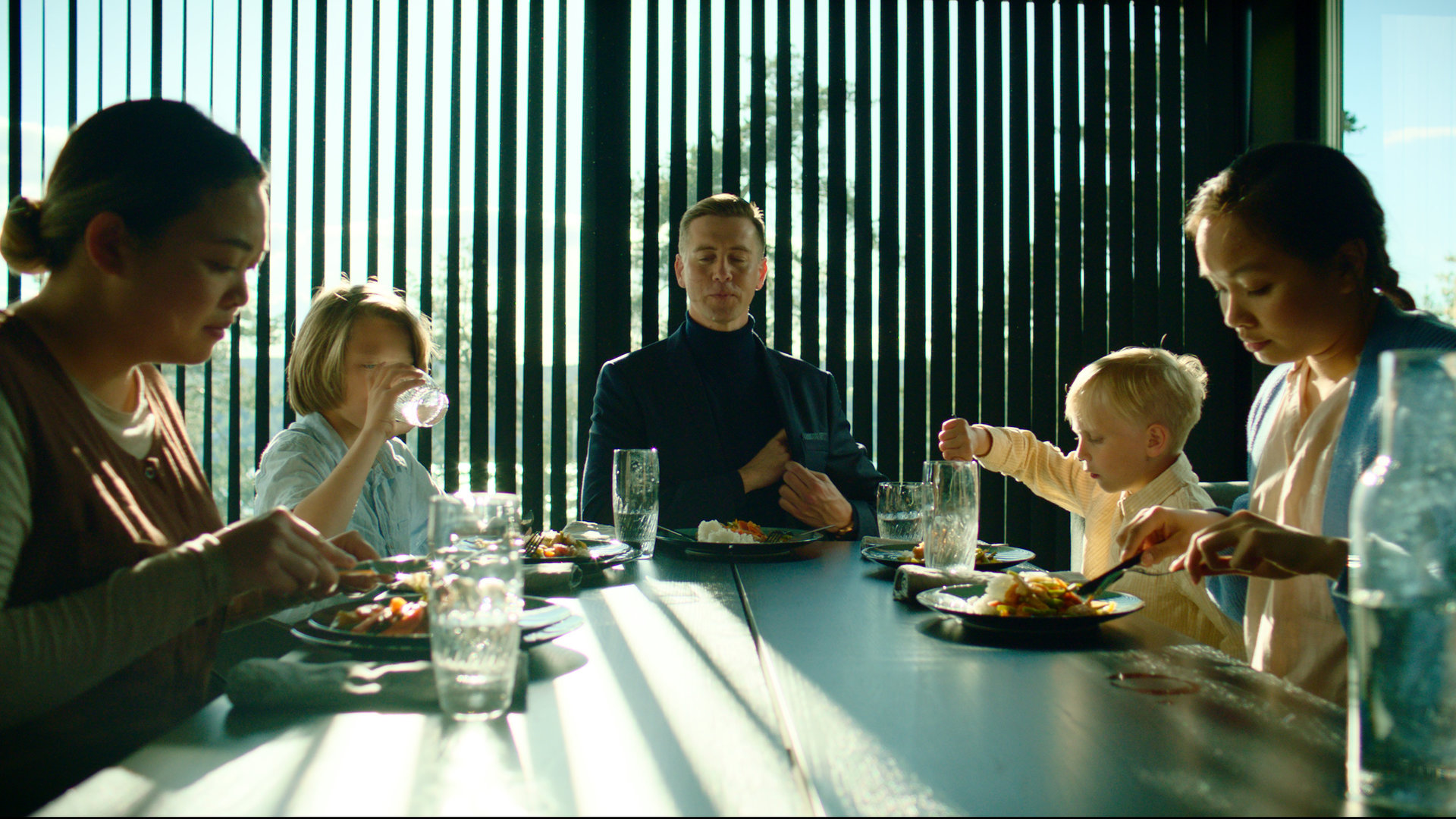 "Exit - Alles auf Anfang": William (Pål Sverre Hagen) sitzt mit Emil (Oliver Krantz-Mikaelsen),  Max (William Øksnevad),  Pim (Catharina Vu) und einer weiteren Au-pair (Vy Luong) an einem Tisch und alle essen zusammen.