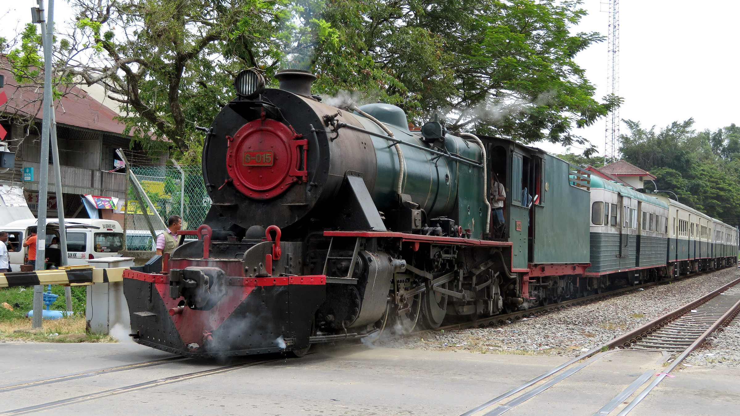 "Borneo - Dampfreise in die Vergangenheit": Eine Dampflok der englischen Vulcan Foundry  aus den 50er Jahren steht vor den restaurierten Reisezugwagen der North Borneo Railway.