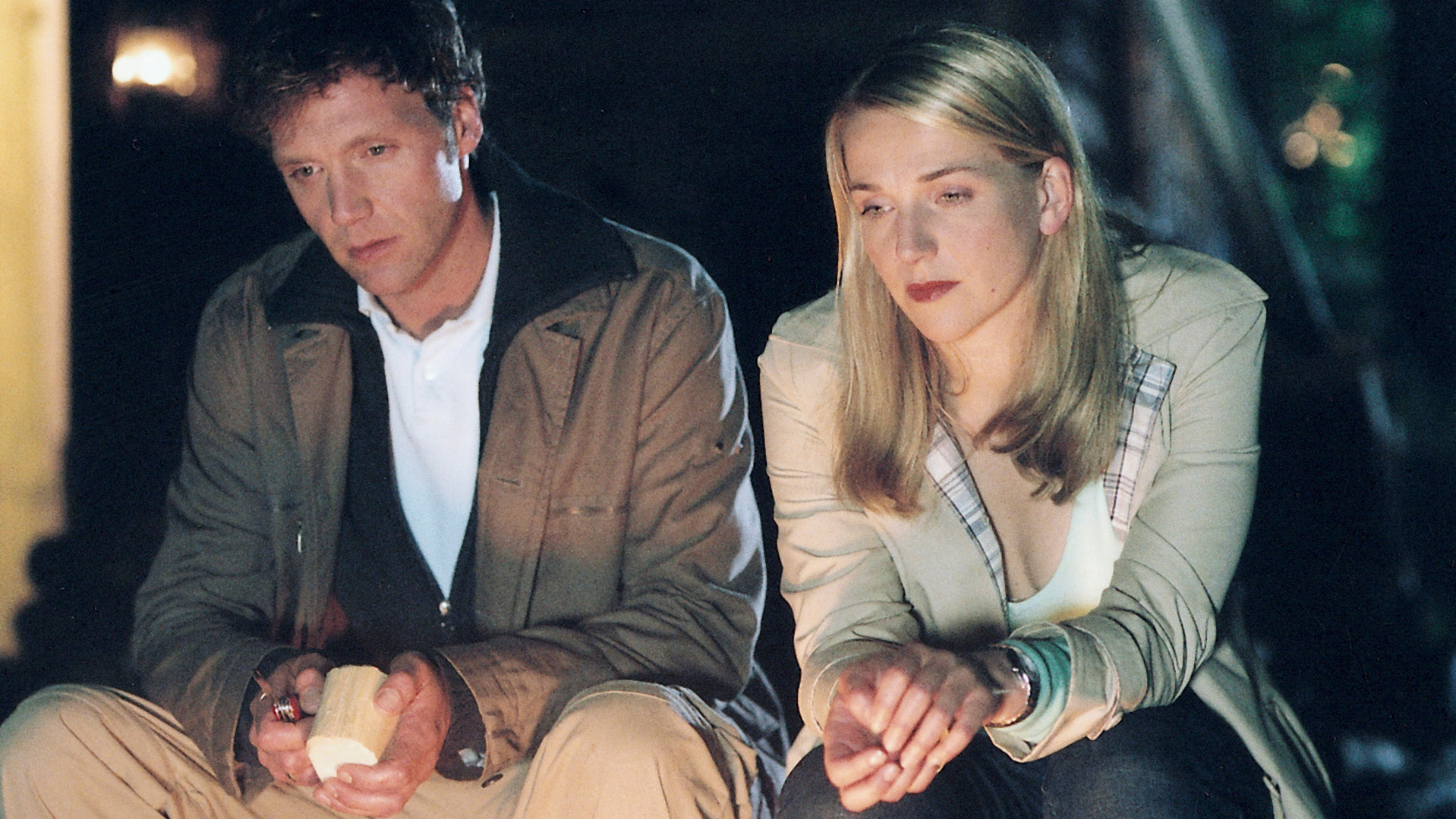 "Bianca - Wege zum Glück: Kapitel 173": Abends vor einer Holzhütte: Oliver (Patrik Fichte) und Bianca (Tanja Wedhorn) sitzen auf einer Veranda nebeneinander. Oliver hat ein Stück Holz und ein Feuerzeug in der Hand. Der Blick der beiden geht nach unten und wirkt sehr betroffen.