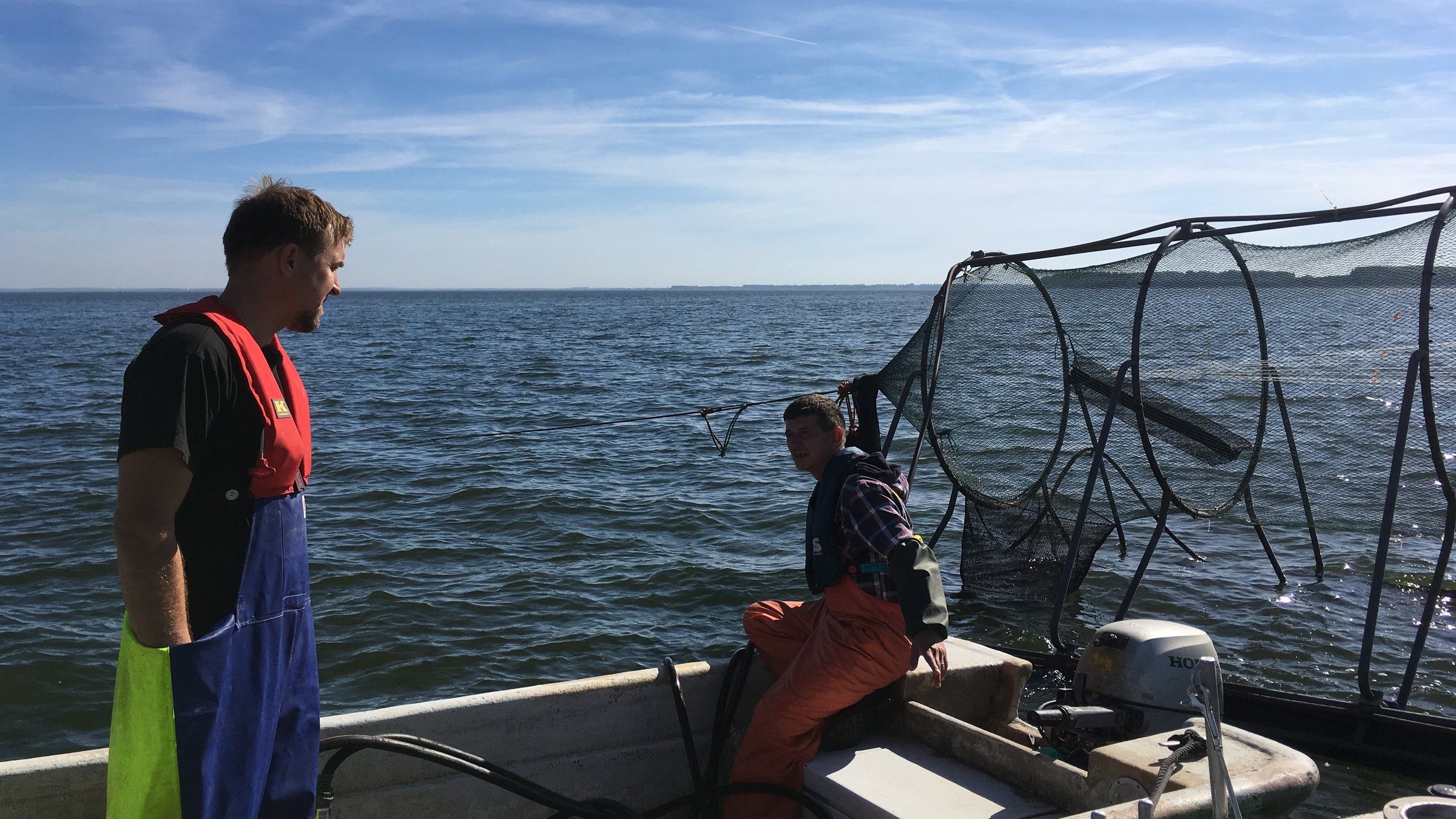 "plan b: Zum Schutz der Meere – Fisch ohne Reue": Daniel Stepputtis und Jan Kuka unterhalten sich auf einem Boot. Hinter ihnen ist die Reuse zu sehen.