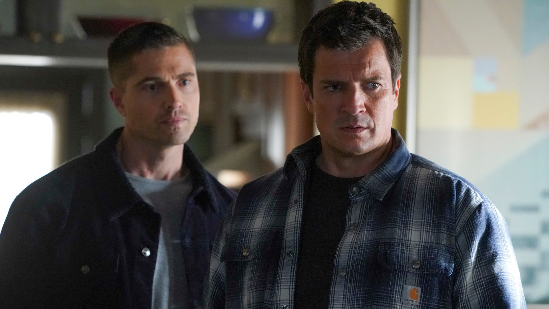 "The Rookie - Das Erdbeben": Tim Bradford (Eric Winter) blickt über John Nolans (Nathan Fillion) Schulter in die Ferne.