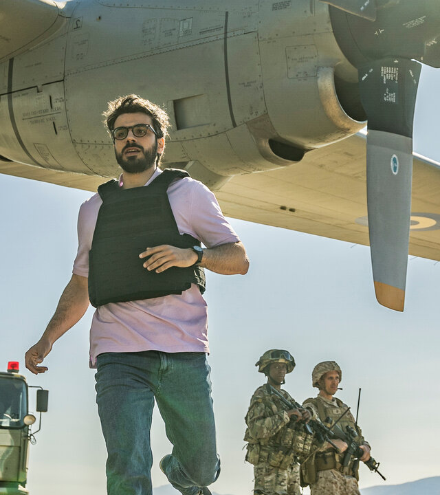 "Kabul - Flucht aus der Hölle: Verhandlungssache": Giovanni (Gianmarco Saurino) befindet sich am Flughafen von Kabul. Er läuft nahe an einem startbereiten Transportflugzeug vorbei, während schwer bewaffnete Soldaten im Hintergrund die Stellung halten. Die Atmosphäre ist angespannt und bedrohlich.