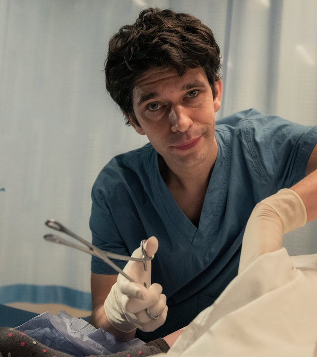 "This Is Going To Hurt - Mal verliert man, mal gewinnen die anderen": Adam (Ben Whishaw) sitzt neben einem Krankenbett und steckt seine Hand unter ein Laken.