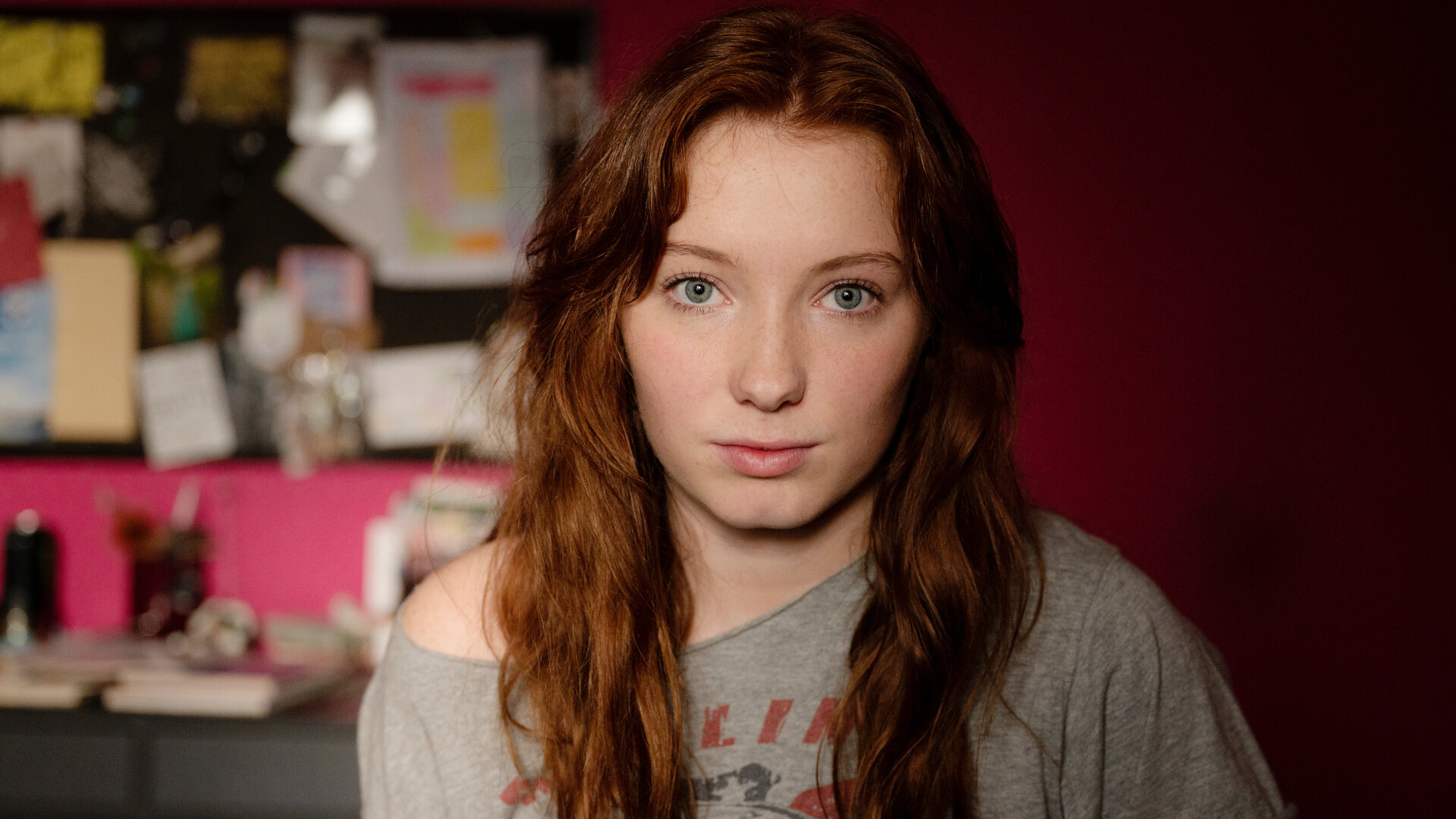 "So Damn Easy Going": Großaufnahme: Joanna (Nikki Hanseblad) steht in einem Zimmer vor einer roten Wand.