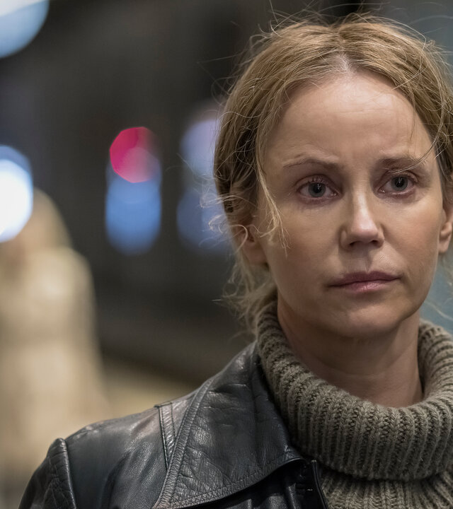 "Iris - Die Wahrheit – Der Fund": Iris Broman (Sofia Helin) steht an einem Bahnhof, der im Hintergrund schemenhaft zu erkennen ist. Sie blickt nachdenklich nach vorne.