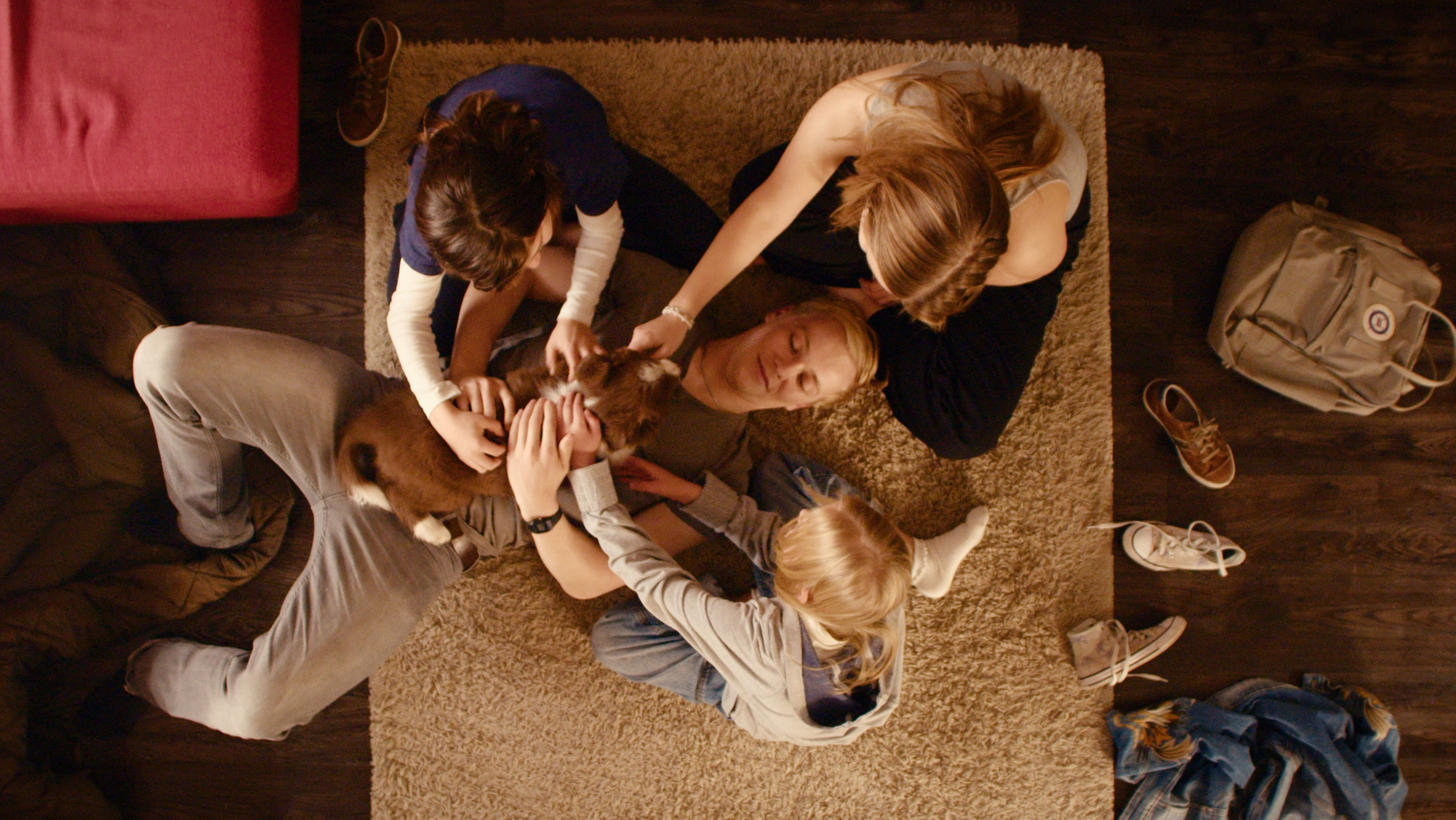 "Gestern waren wir noch Kinder (7)": Daniel Klettmann (Vico Magno), Vivi Klettmann (Julia Beautx) und Emmi Klettmann (Nele Richter) sitzen in einem Kreis. Tim Münzinger (Julius Nitschkoff) liegt in der Mitte mit einem Hund auf dem Bauch, den alle streicheln.