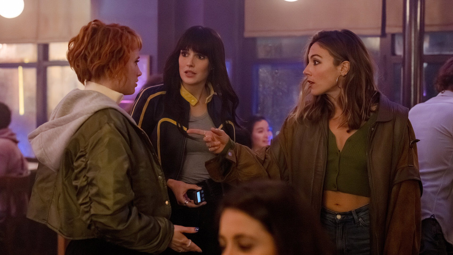 "Cat's Eyes - Quentin": Alexia (Claire Romain), Tamara (Camille Lou) und Sylia (Constance Labbé) stehen nebeneinander in einer Bar. Die Stimmung wirkt angespannt.