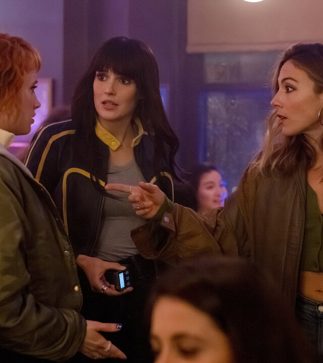 "Cat's Eyes - Quentin": Alexia (Claire Romain), Tamara (Camille Lou) und Sylia (Constance Labbé) stehen nebeneinander in einer Bar. Die Stimmung wirkt angespannt.