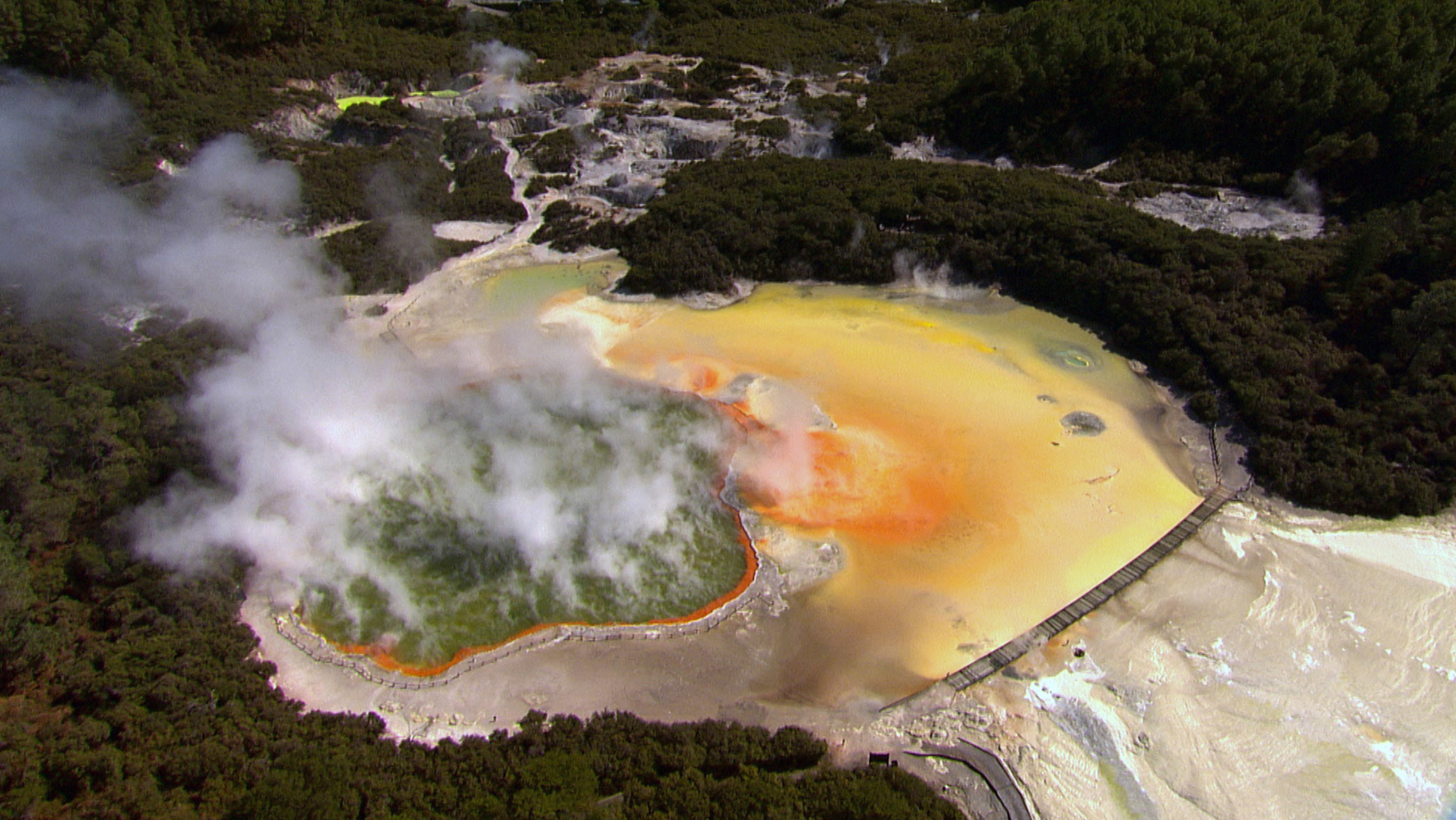 "Neuseeland von oben: Ein Paradies auf Erden - Rauchende Vulkane und dampfende Quellen": Kupfer- und Schwefelablagerungen am Rande dieses Sees in der Thermalregion bei Rotoroa führen zu einem beeindruckenden Farb-Zusammenspiel.