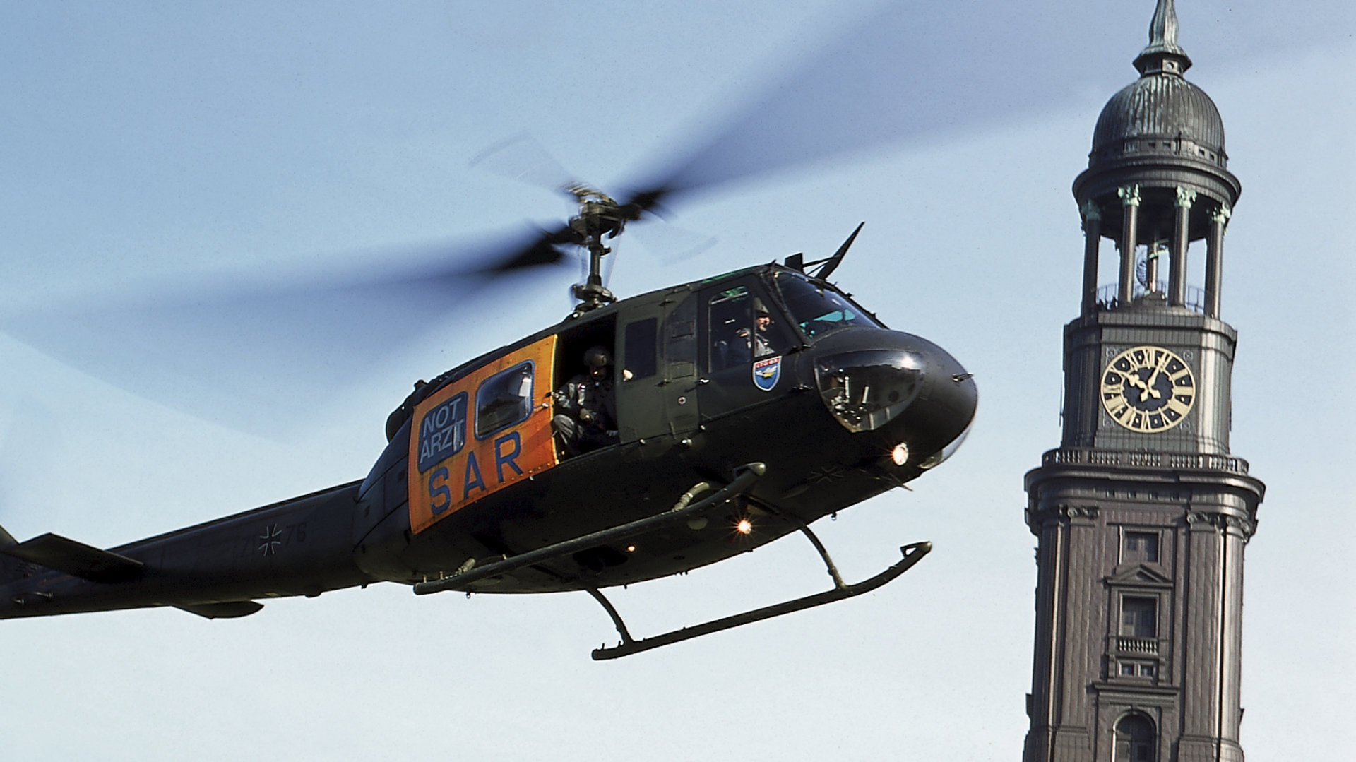 "Die Rettungsflieger - Der Geburtstag": Außenaufnahme - Blick auf den fliegenden Hubschrauber vor dem Hamburger "Michel" - der bekanntesten Kirche der Hanse-Stadt.