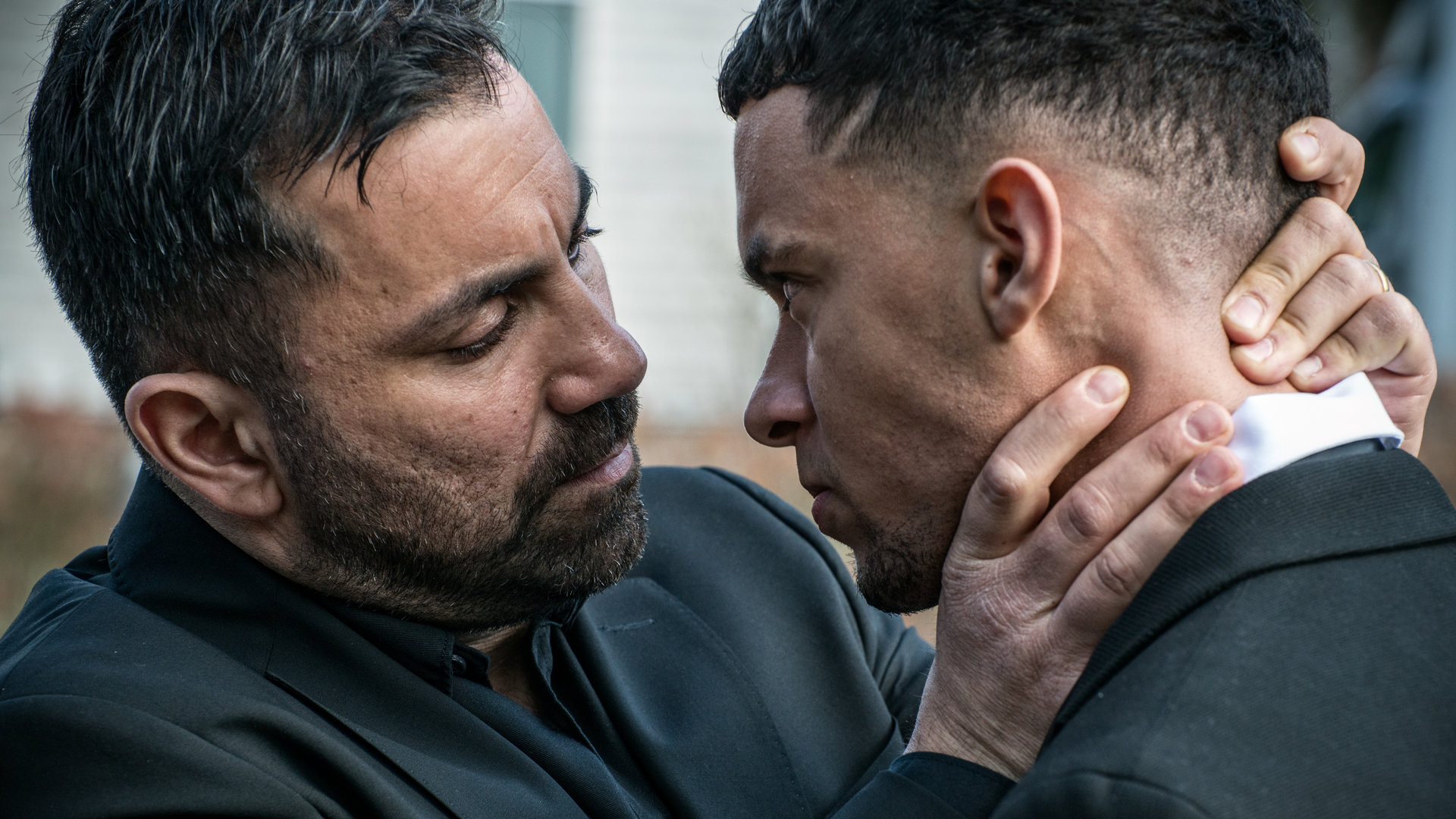 "Hidden Agenda II: Schmerz": Isak (Mahmut Suvakci) und Devin (Maxwell Cunningham) stehen dicht beieinander. Isak greift mit den Händen an Devins Hals und Nacken.