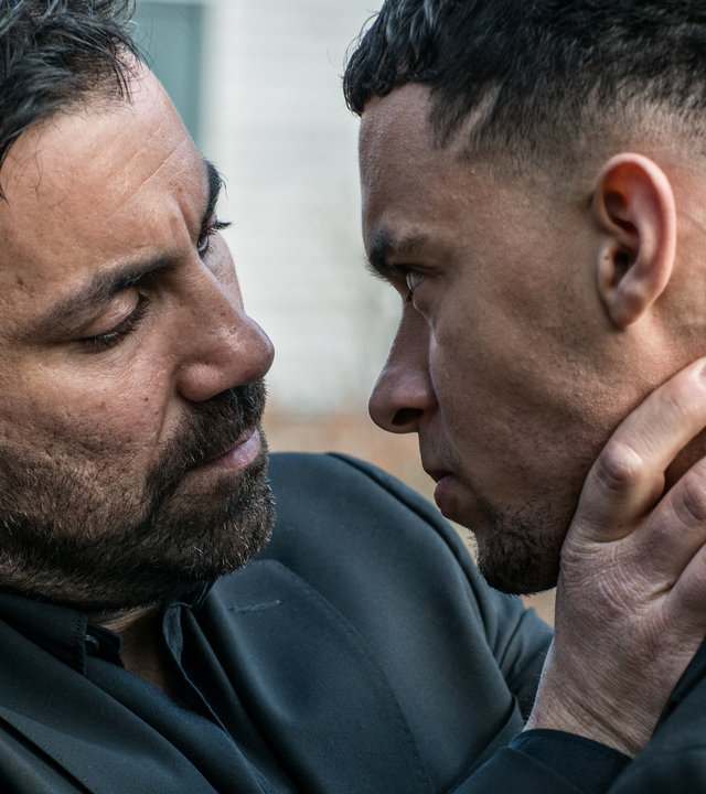 "Hidden Agenda II: Schmerz": Isak (Mahmut Suvakci) und Devin (Maxwell Cunningham) stehen dicht beieinander. Isak greift mit den Händen an Devins Hals und Nacken.