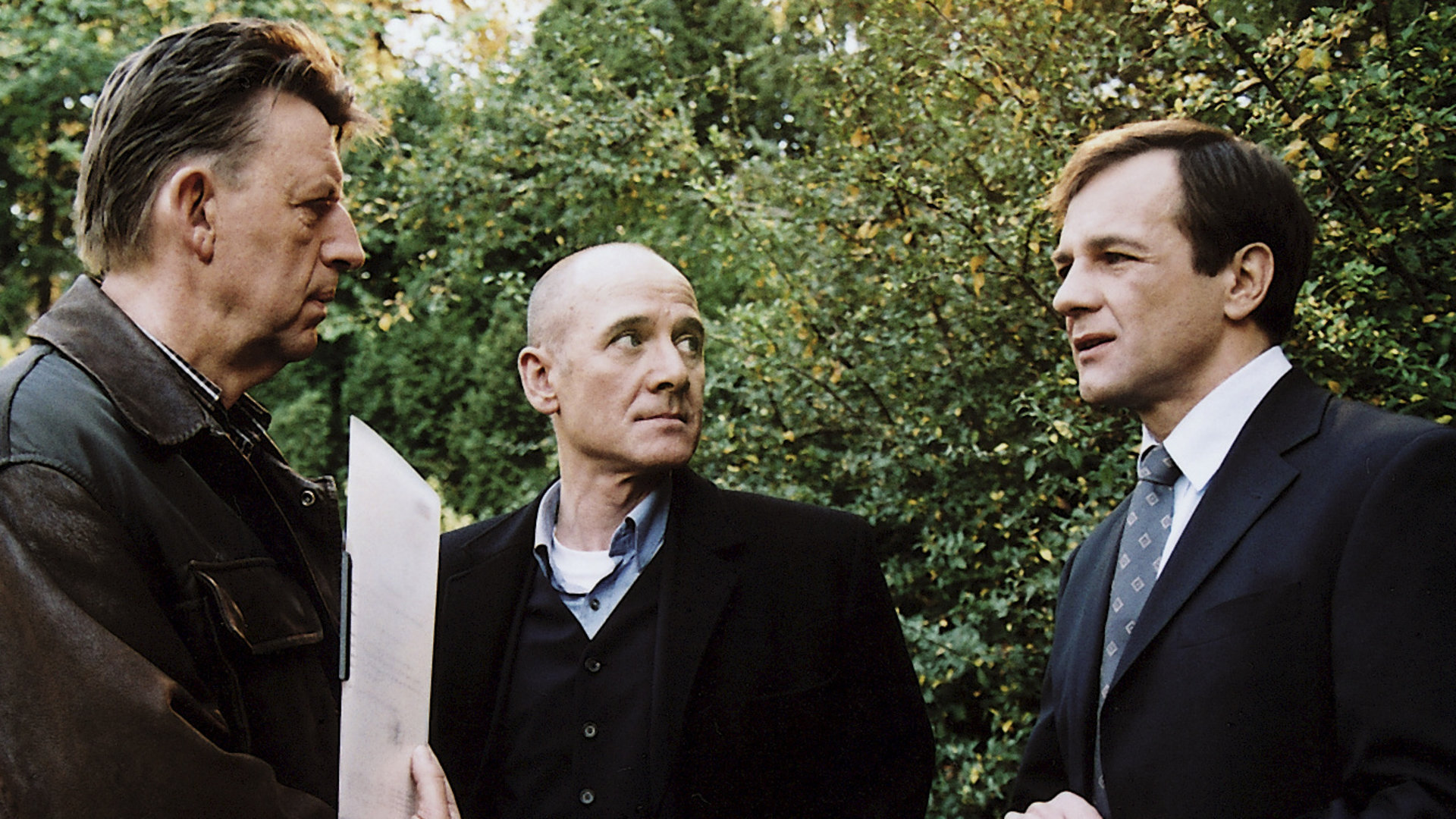 "Der letzte Zeuge - Botschaft des Mörders": Bertram Rademacher (Peter Davor), Joe Hoffer (Jörg Gudzuhn) und Gerichtsmediziner Dr. Robert Kolmaar (Ulrich Mühe) stehen zusammen und besprechen sich.