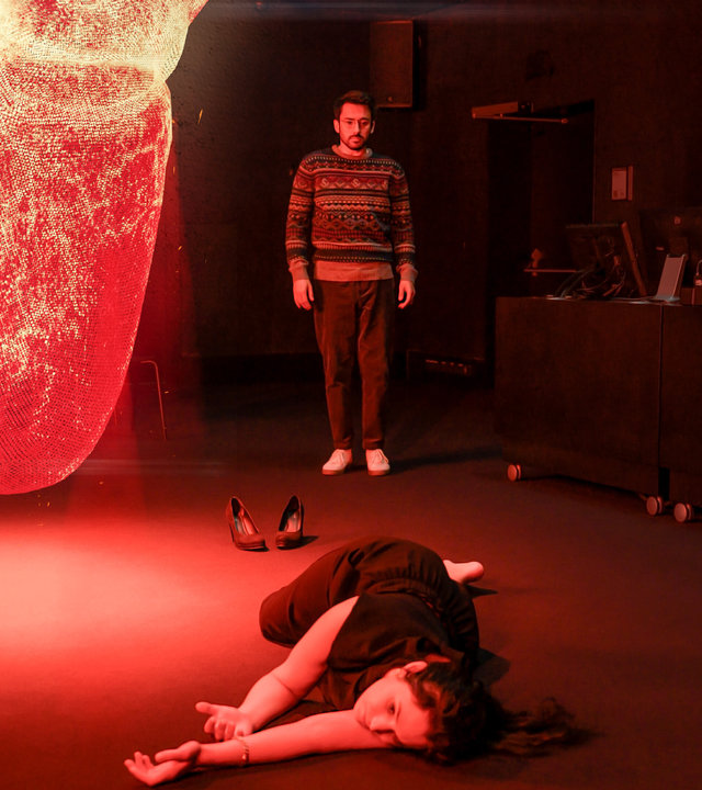 "SOKO Linz- Herzensbrecher": Ein dunkler Lehrraum wird von einem riesigen Hologrammherz rot erleuchtet. Milan Louka (Harwin Krawitz) starrt entsetzt auf den Boden vor sich, auf dem das Opfer liegt.