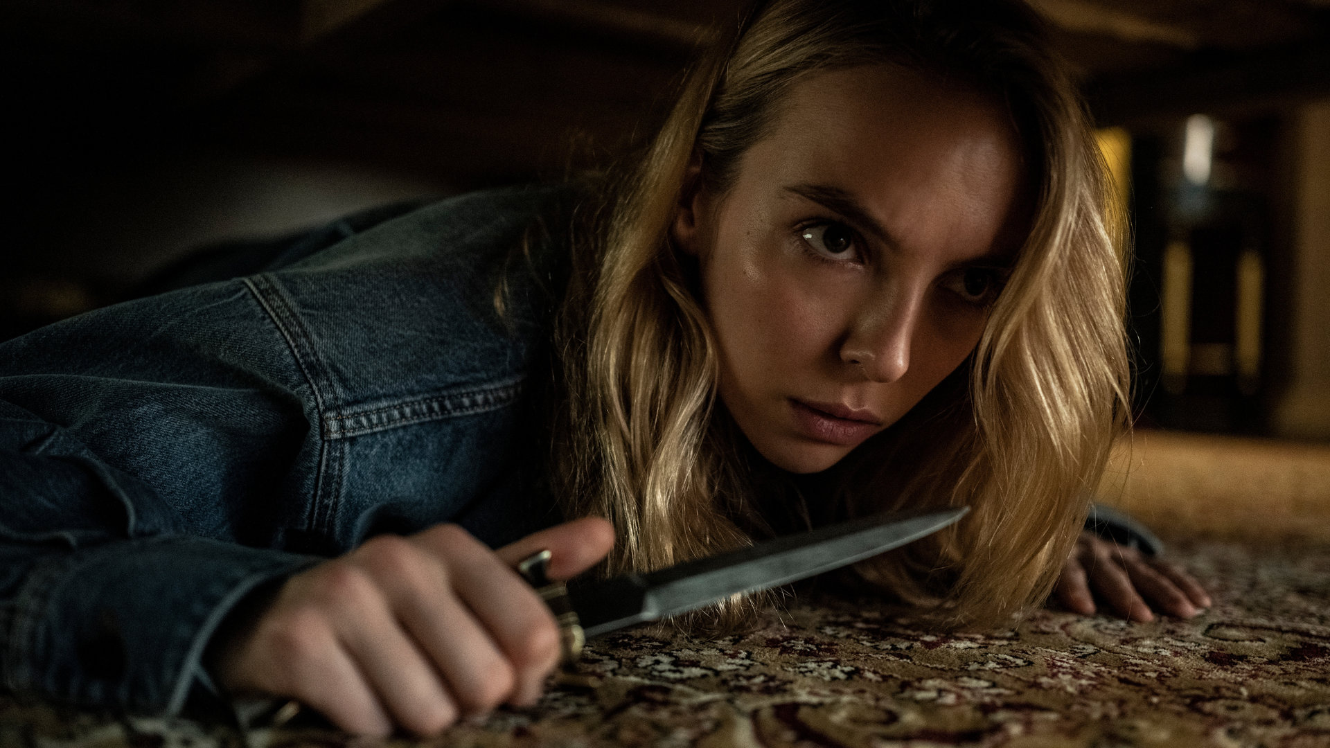 "Killing Eve - Ich bin die Gewinnerin": Villanelle (Jodie Comer) versteckt sich unter einem Bett und schaut konzentriert nach vorne, während sie ein Messer in der Hand hält.