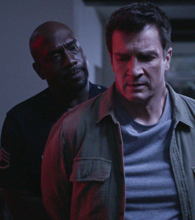 "The Rookie - Abwärts": Nolan (Nathan Fillion) steht mit den Armen hinter seinem Rücken vor Sergeant Grey (Richard T. Jones), der Nolan Handschellen umlegt und ihn dabei ernst anschaut.